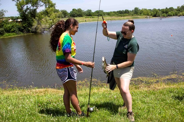 Naturalist helps girl to fish
