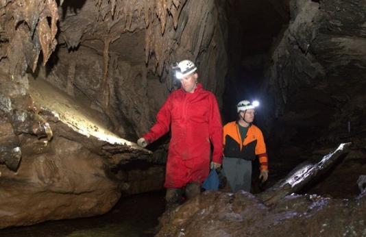 two men explore a cave