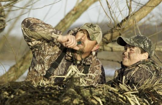 two waterfowl hunters calling ducks